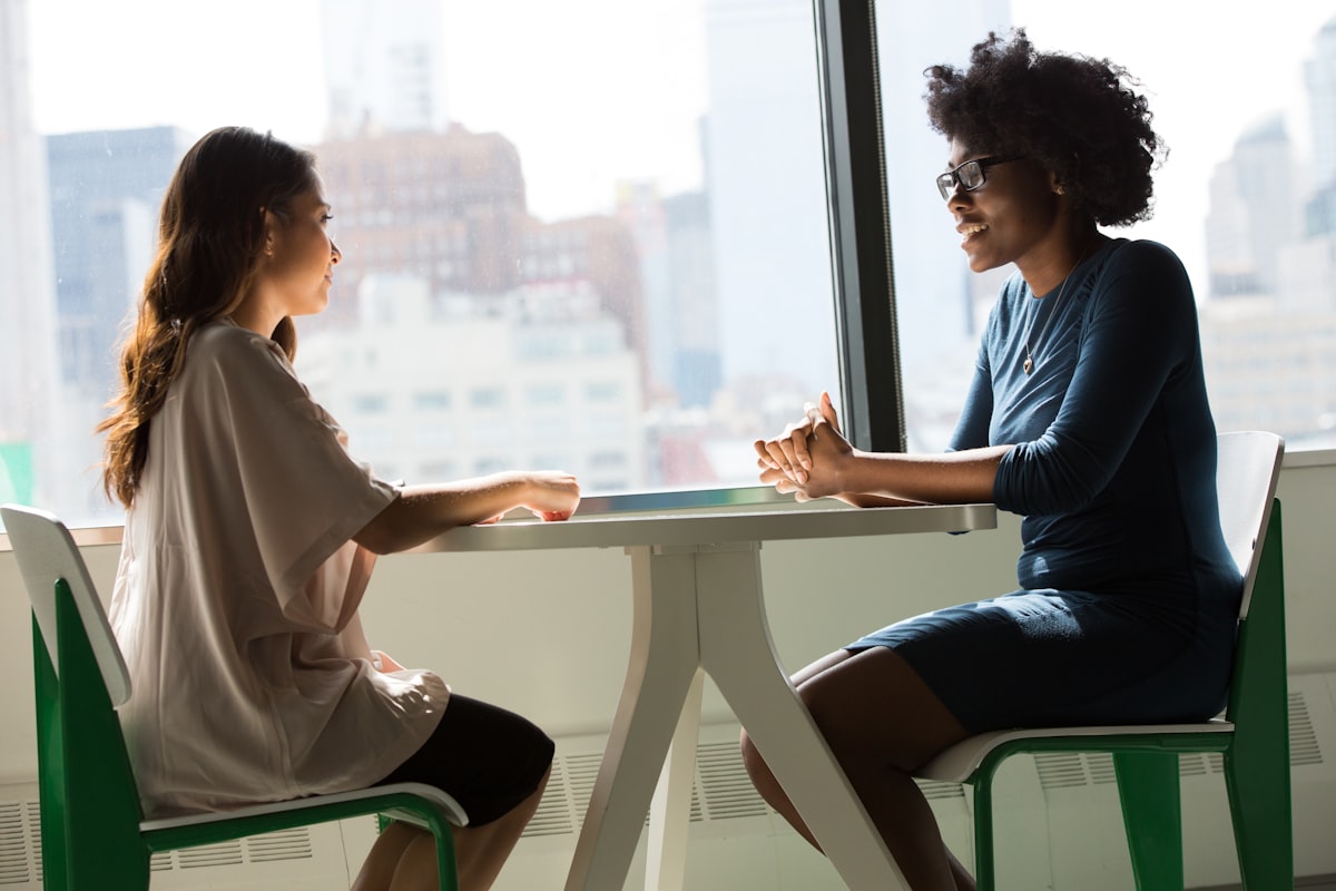 Professional mental health therapy session showing a therapist and client in a comfortable, safe counseling environment